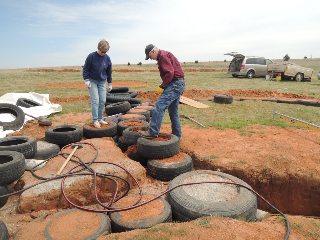 Slamming dirt into tires for foundation of earthbag home