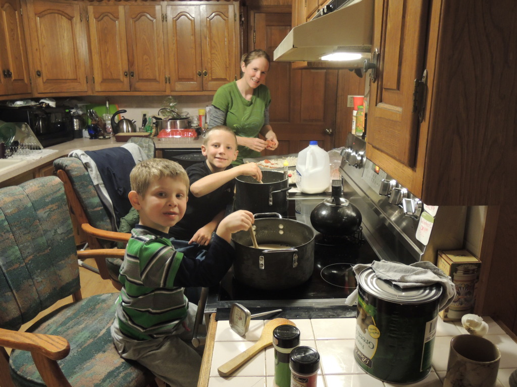 Boys and mom stirring eggnog in kitchen