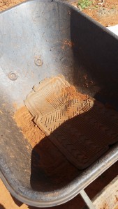 Car mat temporarily fixes the cracked bottom of the wheelbarrow